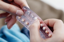 Woman holding birth control packet